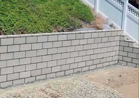 Newly built segmental concrete block retaining wall with gravel backfill